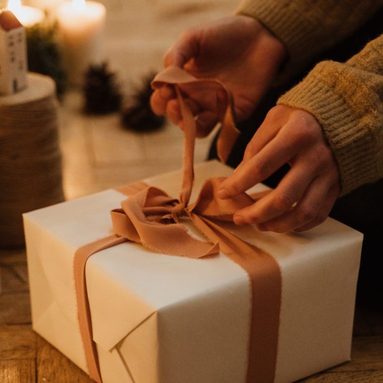 Woman wrapping ribbon on gift